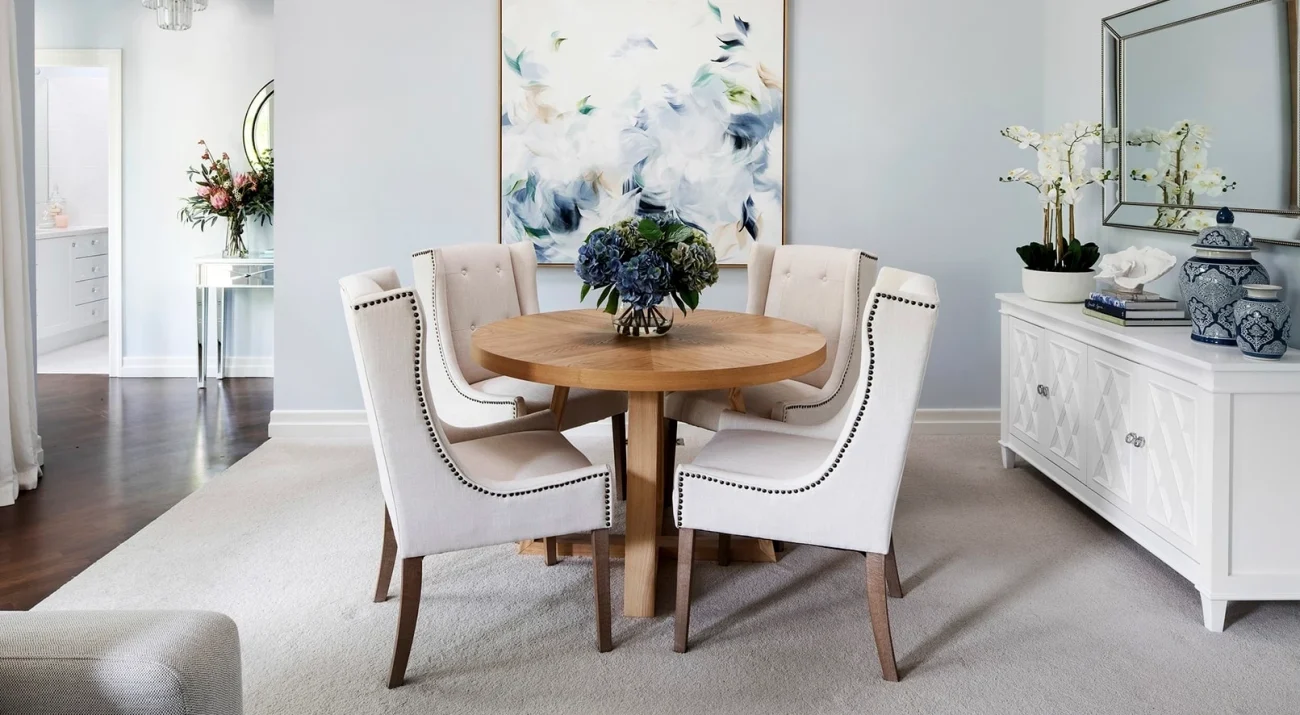 classic hamptons interior design dining room with chalie macrae art on light blue wall e1595672015672